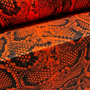 May include: Orange and black fabric with a snake skin pattern.