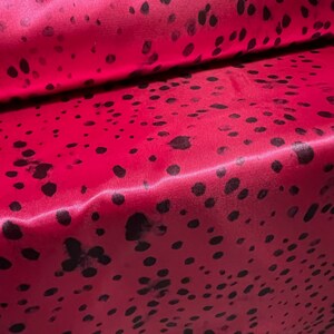 May include: Red satin fabric with a black polka dot pattern.