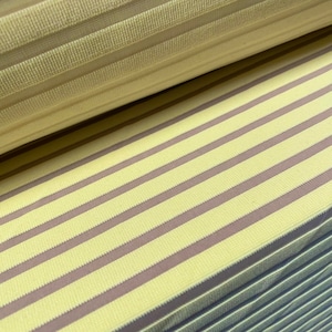 Pode incluir: Close-up de um tecido listrado amarelo e marrom. O tecido tem uma textura canelada.