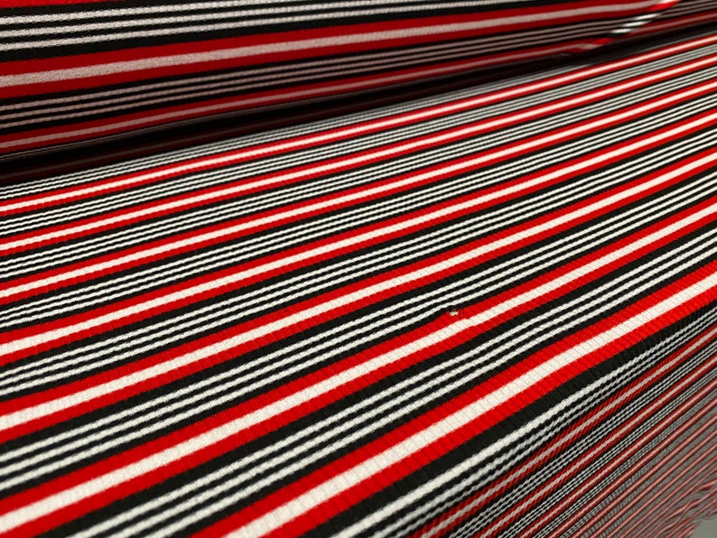 May include: Red, black, and white striped fabric with a ribbed texture.
