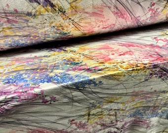 May include: Close-up of a fabric with a floral design. The fabric features a blend of colors, including pink, blue, yellow, and purple, with black linear accents. The design is reminiscent of a watercolor painting, with a soft, flowing aesthetic.