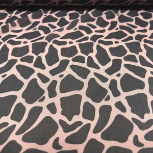 May include: Pink mesh fabric with a black giraffe print pattern.