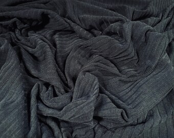 May include: Close-up of a dark gray ribbed fabric with a textured surface. The fabric is folded and draped, creating a soft and flowing look.