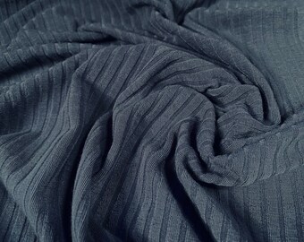 May include: Close-up of a dark blue ribbed fabric. The fabric is soft and textured, with a subtle sheen.