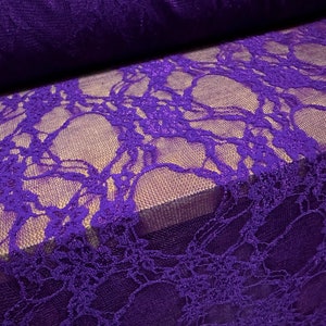 May include: Purple lace fabric with a delicate floral pattern. The lace has a subtle shimmer and is perfect for crafting or sewing projects.