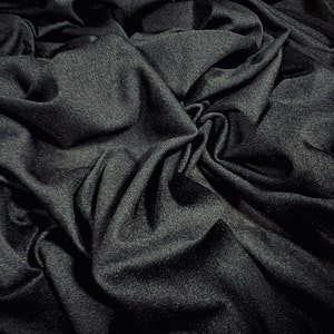 May include: A close-up of a dark gray fabric with a textured surface. The fabric is wrinkled and folded, creating a dramatic and abstract pattern.