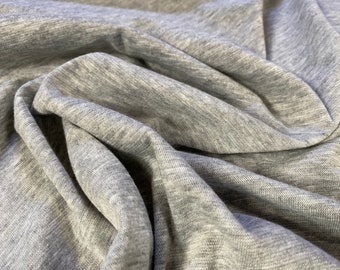 Puede incluir: Primer plano de una tela suave y gris con un sutil patrón jaspeado. La tela está arrugada y tiene una superficie texturizada.