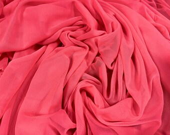 Puede incluir: Primer plano de una tela suave y rosa con una textura transparente y de malla. La tela está drapeada y doblada, creando una apariencia fluida y delicada.