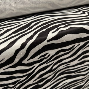 Op de afbeelding: Zwart-witte zebraprint stof met een zacht, gestructureerd gevoel.