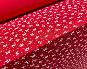 May include: Red fabric with a white floral pattern. The fabric has a subtle texture.