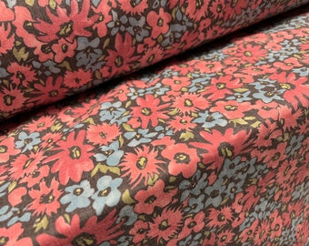 May include: A brown fabric with a pink and blue floral pattern. The fabric is folded in half, showing the pattern on both sides.