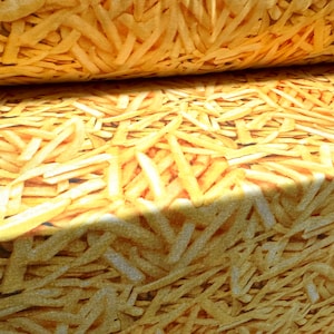 Pode incluir: Um close-up de um tecido com um padrão de batatas fritas douradas. O tecido está dobrado ao meio, mostrando o padrão em ambos os lados.