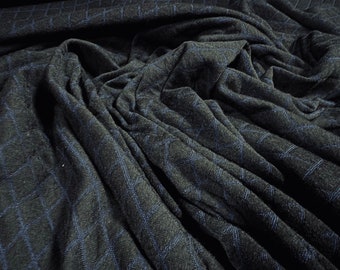 May include: Close-up of a dark gray fabric with a subtle blue geometric pattern. The fabric is wrinkled and textured, creating a soft and cozy look.