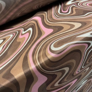 May include: Brown, pink, and white fabric with a swirling, marbled pattern.