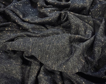 Pode incluir: Close-up de um tecido azul escuro com um brilho sutil de glitter dourado por todo o lado. O tecido é texturizado e tem um toque macio e fluido.