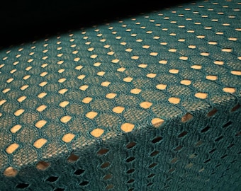 May include: Teal blue fabric with a repeating pattern of small, open circles. The fabric has a textured, woven look.