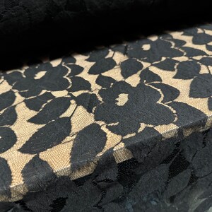 May include: Black lace fabric with a floral pattern. The lace is delicate and has a soft, flowing texture.