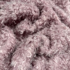 Peut inclure: Gros plan sur un tissu doux et moelleux de couleur mauve avec une texture bouclée.