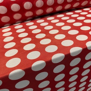 Peut inclure: Tissu rouge à pois blancs. Le tissu est plié en deux, montrant le motif des deux côtés.