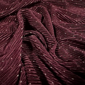 May include: Burgundy pleated fabric with white polka dots. The fabric is soft and has a subtle sheen.