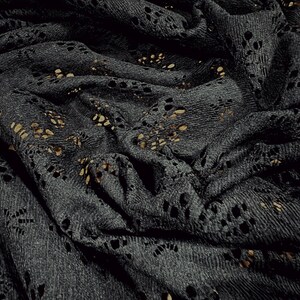 May include: Black lace fabric with a delicate floral pattern. The fabric is soft and has a slightly textured surface.