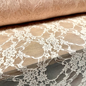May include: White lace fabric with a delicate floral pattern. The lace is sheer and has a soft, flowing texture.