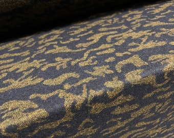 May include: Close-up of a dark blue fabric with a gold patterned design. The fabric has a textured, woven look.