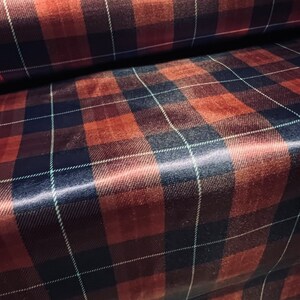 May include: Red and black plaid fabric with a satin finish. The fabric has a subtle sheen and a soft texture.