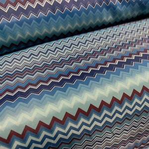Pode incluir: Tecido com padrão chevron azul e vermelho. O tecido tem um efeito degradê sutil com tons de azul e branco.