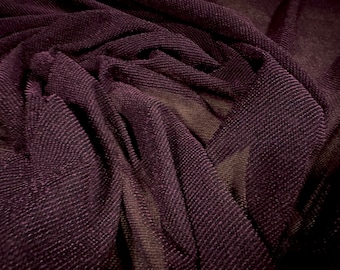 May include: Close-up of a dark purple, textured fabric with a fine mesh weave. The fabric is draped and folded, creating a soft, flowing look.