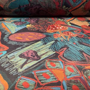 Puede incluir: Primer plano de tela con un dise&ntilde;o colorido y caprichoso. El patr&oacute;n presenta setas, bayas y formas abstractas en tonos de rojo, naranja, verde azulado y marr&oacute;n. La tela parece ser un material tejido.