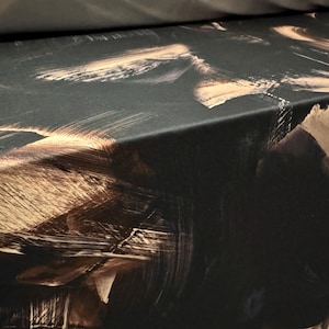 Op de afbeelding: Close-up van een oppervlak met een donkere achtergrond en abstracte penseelstreken in tinten bruin en beige. De textuur lijkt ruw en gelaagd, waardoor een dynamisch visueel effect ontstaat. Het kunstwerk doet denken aan een olieverfschilderij.