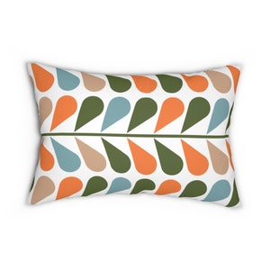 Op de afbeelding: Rechthoekig kussen met een herhalend patroon van druppelvormen in oranje, olijfgroen, beige en blauw op een witte achtergrond. Een groene horizontale lijn verdeelt het patroon.