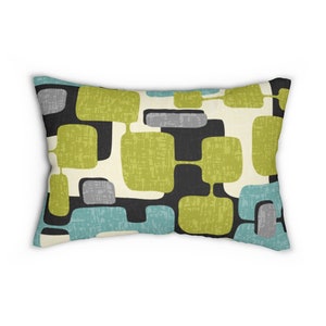 May include: A rectangular throw pillow featuring a geometric pattern in shades of green, blue, grey, and black on a cream background.