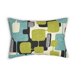May include: A rectangular throw pillow with a geometric pattern in shades of teal, green, black, white, and gray. The pillow has a textured fabric.