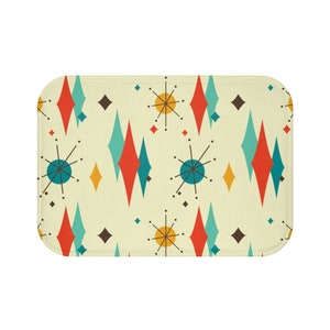 May include: A bath mat with a retro mid-century modern design featuring a repeating pattern of teal, red, yellow, and brown diamonds and stars.