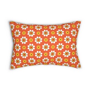 May include: Orange throw pillow with a white and yellow daisy pattern.