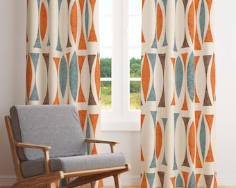 May include: A pair of cream-coloured curtains with a geometric pattern in shades of orange, brown, and blue. The curtains are hung on a window with a view of trees and a house in the background.