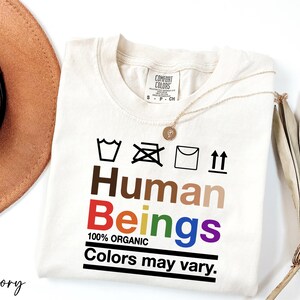 a hat, sunglasses, and a t - shirt with the words human beings on