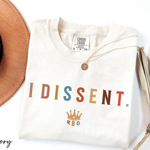 a hat, sunglasses, and t - shirt on a white surface