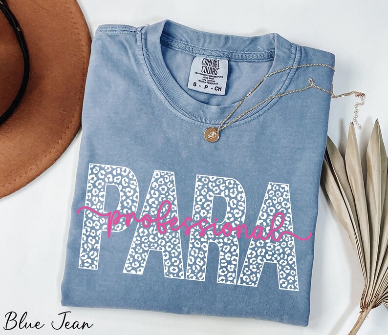 a blue t-shirt with the word "PARA" printed on it, along with a necklace and a hat.