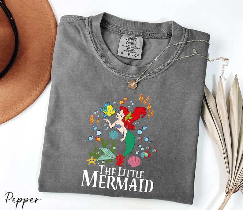a gray shirt with a little mermaid on it