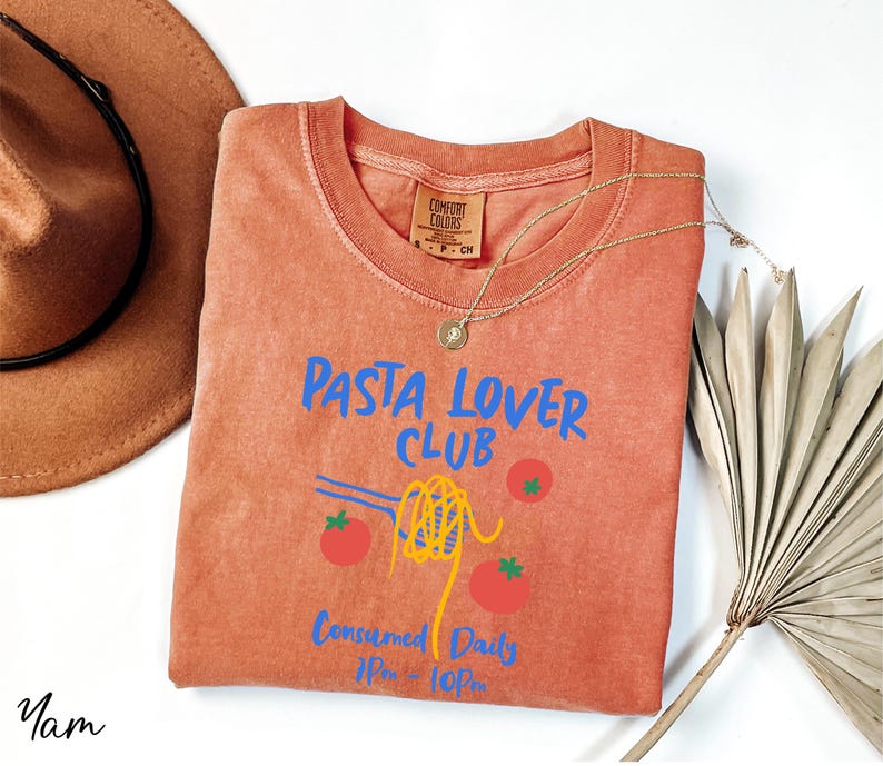 a t - shirt that says pasta lover club next to a hat