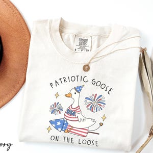 a white shirt with patriotic goose on the loose