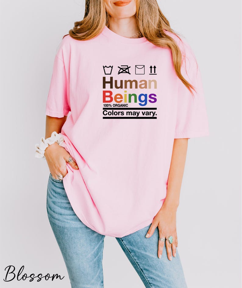 a woman wearing a pink shirt that says human beings