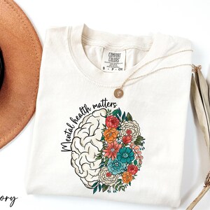 a hat, sunglasses, and t - shirt on a white surface