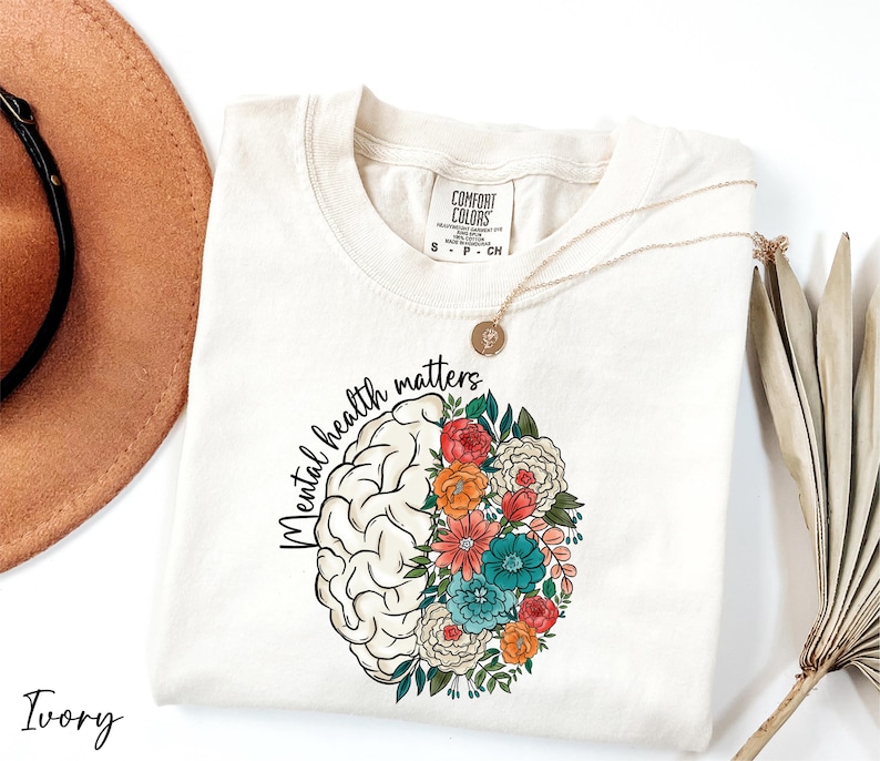 a hat, sunglasses, and t - shirt on a white surface