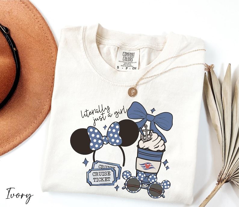 A white t-shirt with a graphic design featuring a cruise ticket, sunglasses, and a bow, along with a necklace and a hat.