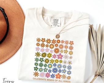 May include: Ivory t-shirt with a colorful floral design and the text "Celebrate Minds of All Kinds".
