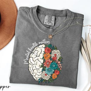 a t - shirt with a picture of a brain and flowers on it